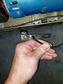 Zbliżenie na rękę trzymającą kabel przy czujniku prędkości bieżni Kettler.