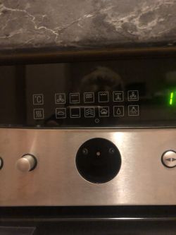 Panel sterowania piekarnika z przyciskami i symbolami funkcji piekarnika.