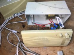 Wnętrze starych głośników komputerowych z widoczną elektroniką i transformatorami.
