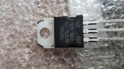 Tranzystor STMicroelectronics TIP31C leżący na przezroczystym folii bąbelkowej.