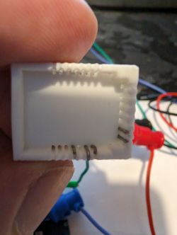 Plastic Module Holder with Visible Pins Close-up of a plastic holder for a module with visible pins inside.