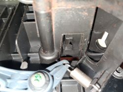 Wnętrze ekspresu do kawy DeLonghi ECAM, z widoczną luźną sprężynką i elementami mechanizmu w środku.