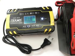 TEKAN ELECTRONICS battery charger with display, cables, and power plug, partially visible battery.