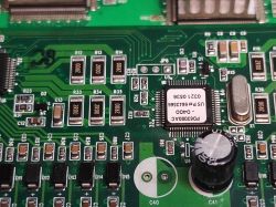 Zbliżenie na fragment płytki drukowanej ze starym układem PD63000AC oraz elementami elektronicznymi powierzchniowymi.