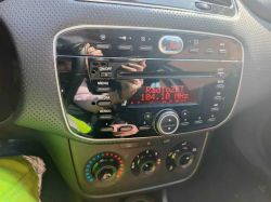 Panel radia samochodowego z czerwonym wyświetlaczem „RadioZET 104.10 MHz” w konsoli środkowej