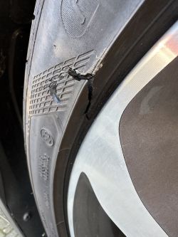 Pęknięta przednia prawa opona samochodowa.