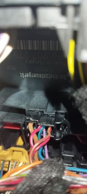 Zbliżenie na złącze elektryczne z kolorowymi przewodami w samochodzie.