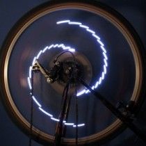 Ring of white light dots on a wheel rim, photographed in darkness