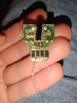Zasilacz do LED w lampie elektrycznej trzymany w dłoni.