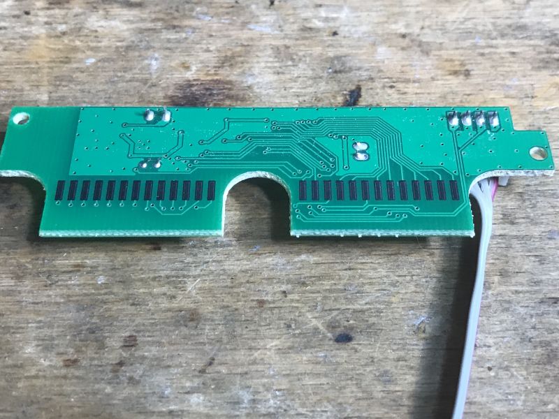 Widok płytki PCB z klawiatury bezprzewodowej z widocznymi ścieżkami i złączem.
