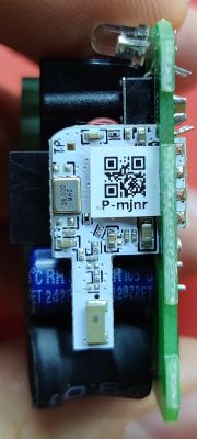 Close-up of a small PCB with electronic components and a QR code label