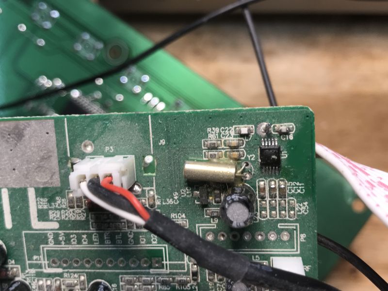 Close-up of a PCB with a resonator, connector, and IC near labeled components