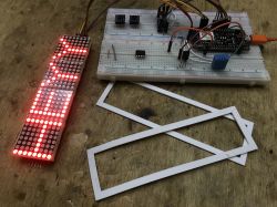 Microcontroller-Controlled LED Display Prototype LED display and prototype board on a workbench.
