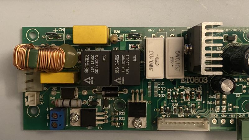 Zbliżenie płytki PCB ET0803 z przekaźnikami, cewką i radiatorem; widoczne opisy elementów i złączy