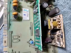 Zbliżenie płytki drukowanej z elementami elektronicznymi i naklejką kontroli jakości