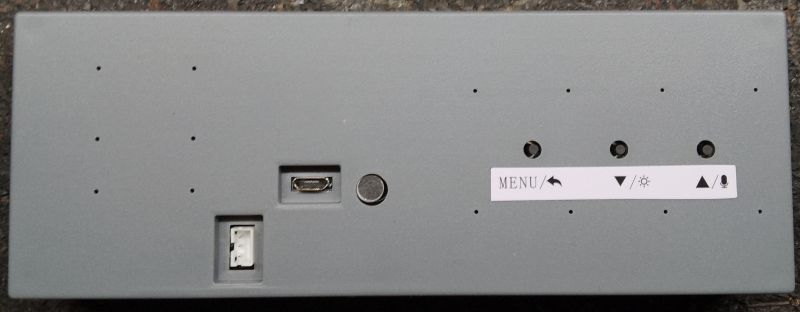 Szara obudowa z portami i przyciskami na tylnej ściance analizatora widma audio.