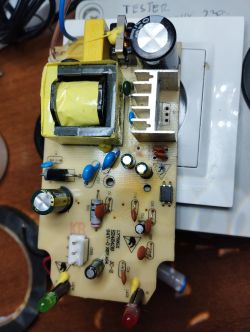 Circuit board with various components like capacitors, resistors, and a transformer.
