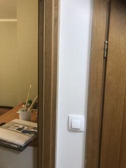 Podwójne drzwi z włącznikiem światła przy ścianie.