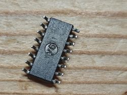 SOIC-16 integrated circuit with markings on a wooden background.