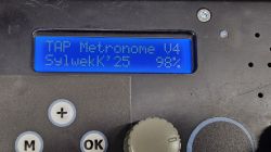 Wyświetlacz LCD domowego metronomu elektronicznego z napisem TAP Metronome V4 SylwekK'25 98% oraz fragmentami przycisków sterujących.