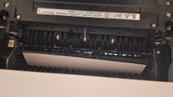 Widok wnętrza urządzenia Ricoh Aficio MP C2050 z zaciętym papierem w sekcji duplex.