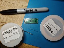 Microcontroller, wire coils, and a Sharpie marker on a table.