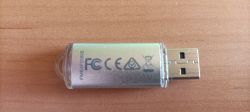 Pendrive USB z metalową obudową i przezroczystymi końcówkami na drewnianym blacie