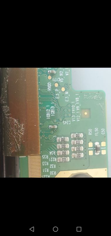 Close-up of a green PCB with 470 and 000 SMD resistors next to a brown LCD flex ribbon connection.