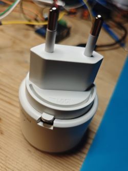 Electrical plug with RESET label and locking mechanism on a wooden surface.