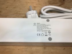 Woox R4027 Power Strip Technical Label Label of Woox R4027 power strip with technical data on a wooden background.