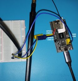 ESP-12 module connected to breadboard with signal wires on blue surface