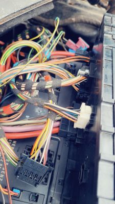 Wiązka kabli elektrycznych w samochodzie z widoczną kostką i wtyczkami.