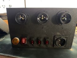 Black bulb tester front panel with three E27 lamp holders, rocker switches, and a Schuko outlet