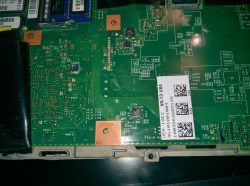Zdjęcie obwodu drukowanego z widocznymi elementami elektronicznymi, śladami kleju lub wody.