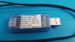 Tester USB Keweisi KWS‑V20 w przezroczystej obudowie na niebieskim tle