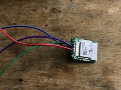 Electronic Module with Wires Electronic module with attached colored wires on a wooden background.