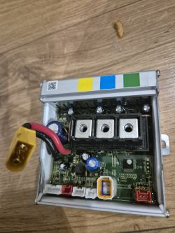 Zdjęcie sterownika elektronicznego na drewnianej powierzchni.