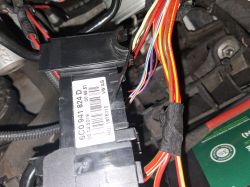 Electrical system component with visible wires and a label with number 6C0941824D in a car.