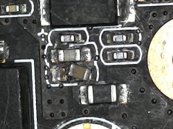 Close-up of a damaged SMD component on a PCB.