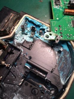 Uszkodzona elektronika z wyraźną niebieską korozją i uszkodzoną płytką PCB