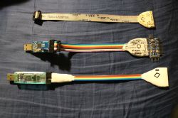 Trzy kable USB z adapterami i przejściówkami do programowania mikrokontrolerów.