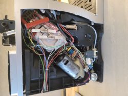 Wnętrze ekspresu do kawy Delonghi z widocznym okablowaniem i podzespołami