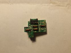 Płytka PCB z elementami elektronicznymi na tle białej powierzchni.