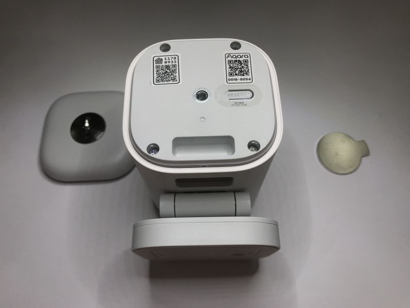 Dolna część kamery Aqara z widocznym przyciskiem reset i kodami QR