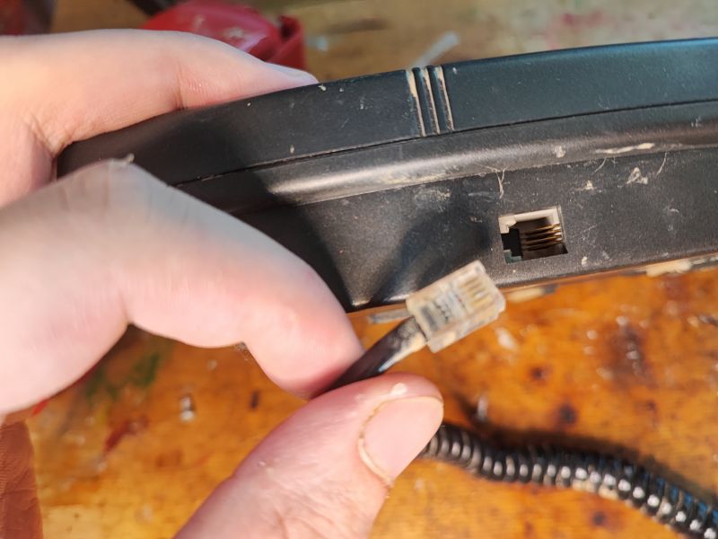 Port na kabel telefoniczny w słuchawce telefonu stacjonarnego z lat 90.