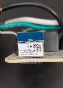 Close-up of an electronic module labeled CB2S, with a visible QR code and serial numbers.