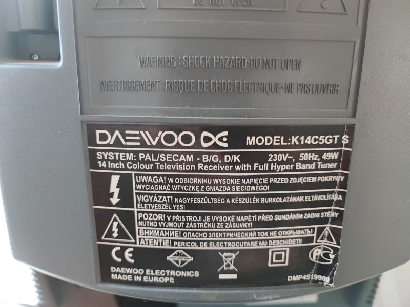 Tył telewizora kineskopowego Daewoo K14C5GT, z widoczną tabliczką znamionową i informacjami o systemie oraz ostrzeżeniem przed wysokim napięciem.