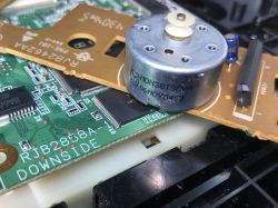 Zbliżenie na płytkę elektroniczną DVD z widocznym silnikiem DC.