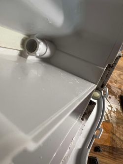 Widok wnętrza plastikowego dozownika na płyn z zaworkiem.