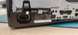 Zbliżenie tylnego panelu konsoli Xbox 360 Slim z widocznym gniazdem zasilania i etykietą.
